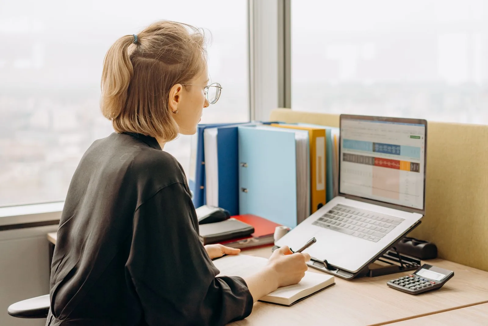 A school administrator reviewing a report on her laptop in an office